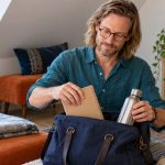 Preparing for a Reiki Attunement: What Helps, What to Skip, and What Never to Do A man packs a notebook and water bottle into a canvas bag.
