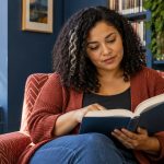 Do You Have to Believe in Reiki? What Belief Changes, and What It Doesn’t A woman reads thoughtfully in a library armchair.