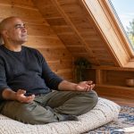 The Power of Reiki: What It Really Is, in Brief A man rests on a thick floor cushion in a cedar-paneled loft, with his hands relaxed on his thighs.