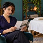 Reiki, What Is It? A Plain-English Explainer for Sceptics and First-Timers A woman reads an information brochure beside an empty treatment table.
