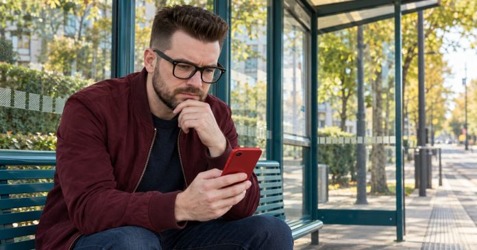 Toxic Relationships: The Signs, the Line Between Toxic and Abusive, and How to Step Back — cover A man sits at an open-air stop holding a red smartphone.