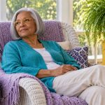 Reiki Benefits: What People Report and What the Evidence Supports An older woman rests in a woven recliner on a bright porch.