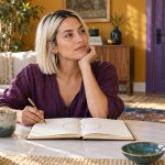 Soul Contracts, Soulmates and Twin Flames: What the Terms Mean, and an Honest Guide to Using Them A woman reflects over an open journal at a low writing desk.