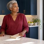 Empaths and Emotional Vampires: Relationship Patterns Explained A woman closes a notebook after a moment of reflection at a kitchen counter.