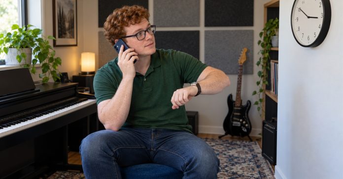 Boundary Phrases for Draining Conversations: Practical Examples — editorial cover A man checks the time during a phone conversation in a home music room.