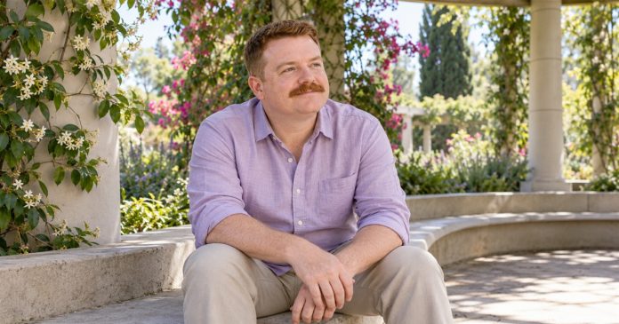 A man sits quietly in a botanical garden pavilion for a moment of reflection.