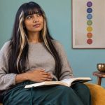 Signs Your Chakras Are Blocked: A Reflective Guide, Not a Diagnosis A woman pauses with an open notebook during a seated reflection.