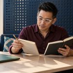 Intuition and the Four Clairs: What They Really Are, and How to Develop Them Honestly A man compares written observations in a notebook at a triangular desk.