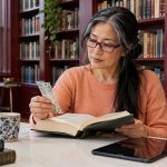 Past-Life Regression and “Body Testing”: What the Research Shows, and What to Do Instead About Unexplained Fears A woman reads a book at a quiet library table.