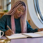 Intuition Exercises Worth Keeping: Three That Include Feedback, in Brief A woman compares notes in an open journal at a library desk.