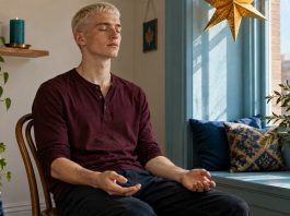 Asking Archangel Michael to Clear Your Energy: A 10-Minute Visualisation, Honestly Described A young man sits quietly with relaxed hands in a sunlit window niche.