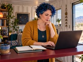 Avoiding Mistakes in Psychic Affiliate Marketing: 10 Errors, the Fix for Each, and the Disclosure Rule That Comes First A woman reviews an article draft on a laptop at a standing desk.